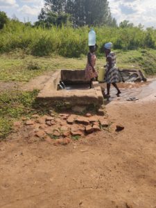 Frauen schleppen Wasser vom Brunnen